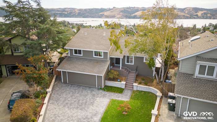 Home exterior featuring Timber Bark HardiePlank siding and Arctic White HardieTrim in Benicia, CA. Scenic background visible
