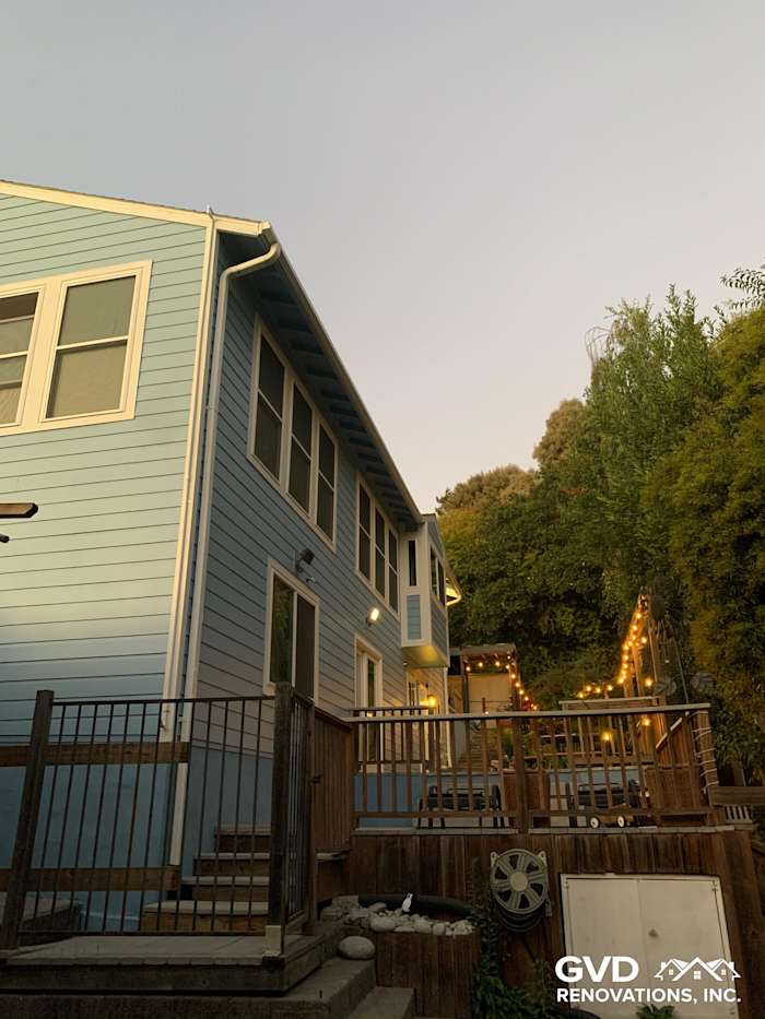Custom Colonial Smooth Lap James Hardie siding in blue with vinyl windows on a remodeled Oakland home exterior