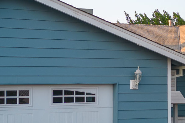 Home exterior featuring new blue Alside Prodigy vinyl siding and a garage with a white door
