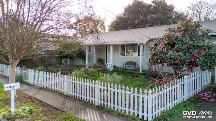 Updated home exterior in Napa featuring James Hardie Cobble Stone siding, Arctic White trim, and a white picket fence