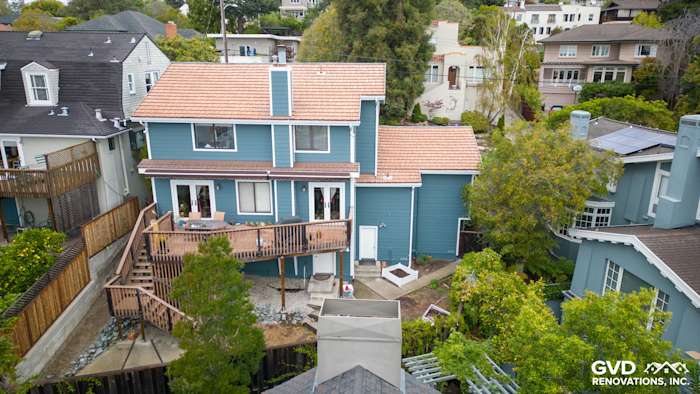 Oakland home featuring Evening Blue HardiePlank siding and Arctic White trim, surrounded by lush greenery