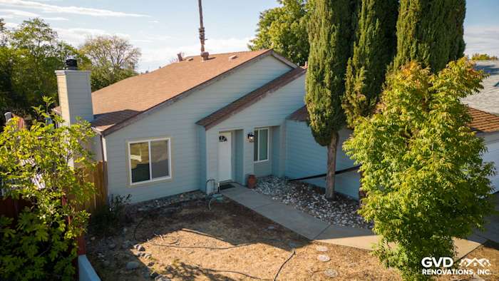 Freshly installed James Hardie Lap Siding in light blue on a Sacramento home exterior, featuring lush landscaping