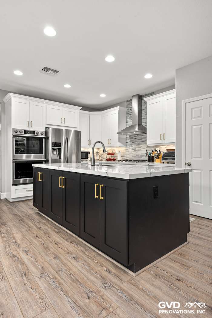 Modern kitchen remodel in Roseville with black island cabinets, Cambria countertops, and sleek stainless-steel appliances
