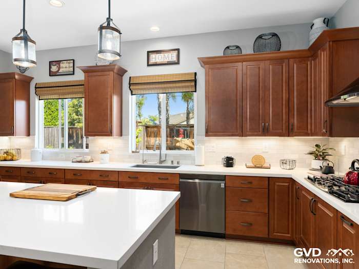 Modern kitchen remodel featuring dark wooden cabinets, quartz countertops, and stainless steel appliances in Elk Grove