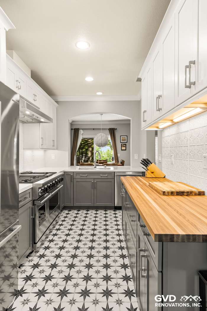 Modern kitchen remodel in Folsom featuring gray cabinetry, wood countertop, and stunning star-patterned tile floor