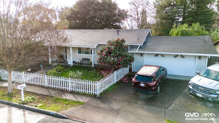 Exterior view of a Napa home featuring new James Hardie siding, Anlin windows, and a manicured front yard with fence