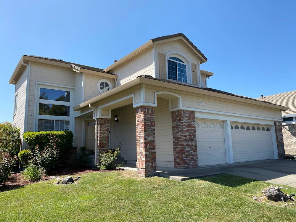 Two-story home with brick accents, light siding, and well-maintained landscape in Northern California