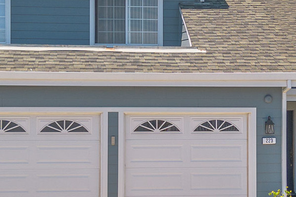 Two-story home exterior in Foster City featuring James Hardie Boothbay Blue siding and Arctic White trim, with a landscaped