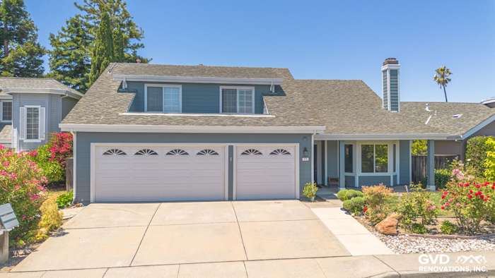 Two-story home exterior in Foster City featuring James Hardie Boothbay Blue siding and Arctic White trim, with a landscaped