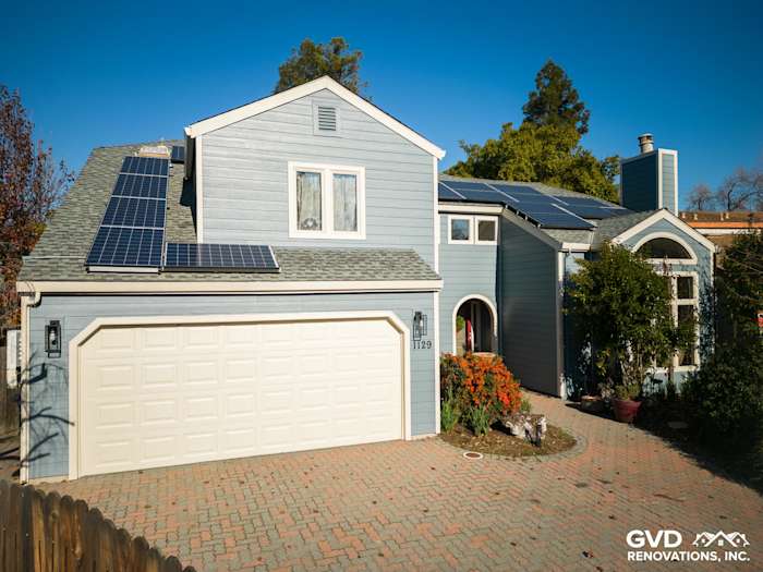 Home exterior featuring James Hardie Boothbay Blue siding, solar panels, and a stone-paved driveway