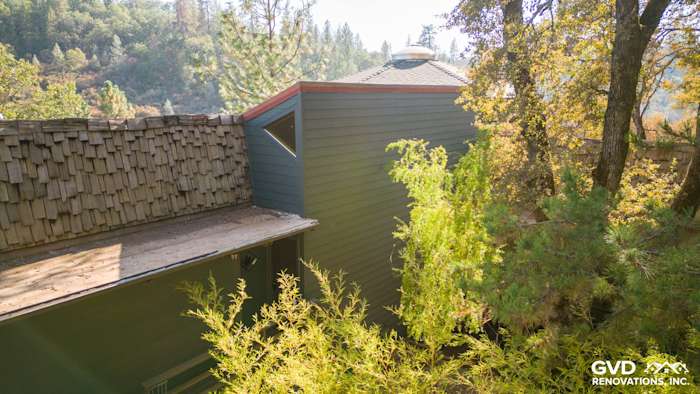 Iron Gray James HardiePlank siding on a unique home exterior in Meadow Vista, surrounded by trees and foliage