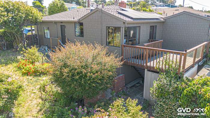 Home exterior featuring James Hardie Shake and Shingle siding in a muted brown color, surrounded by greenery and a wooden