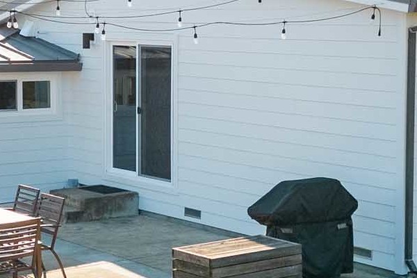 Fresh Arctic White James Hardie siding on a remodeled Sonoma home, showcasing a clean, modern exterior and backyard