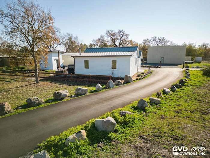 Home exterior in Sonoma featuring new Arctic White James Hardie siding and landscaped driveway with boulders