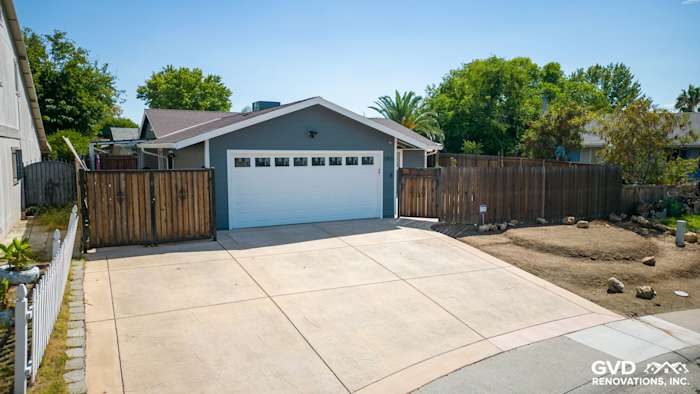 House exterior featuring James Hardie Night Gray lap siding and Arctic White trim, with a driveway and garage