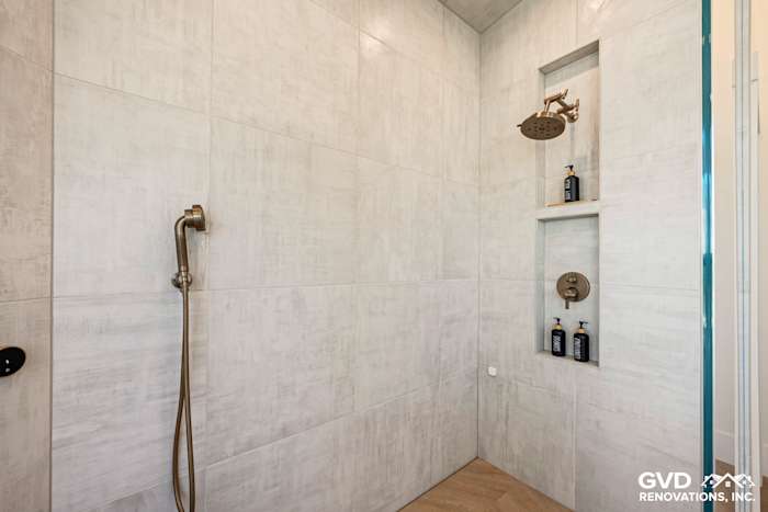 Zero-threshold steam shower with custom tile, built-in shelving, and luxurious fixtures in El Dorado Hills bathroom remodel