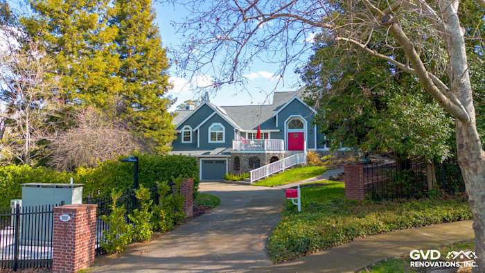 Home exterior featuring Night Gray James Hardie siding, Arctic White trim, and a vibrant red front door in Petaluma