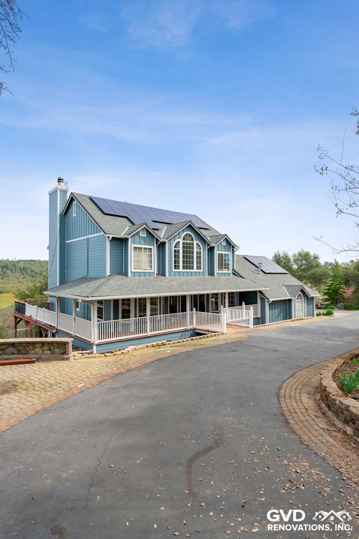 Newly installed blue James Hardie siding on a large home with a stone driveway in Shingle Springs, CA