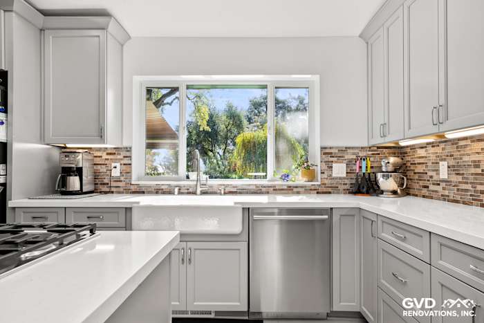 Modern kitchen remodel in Greenwood featuring gray cabinets, quartz countertops, and a stylish tile backsplash