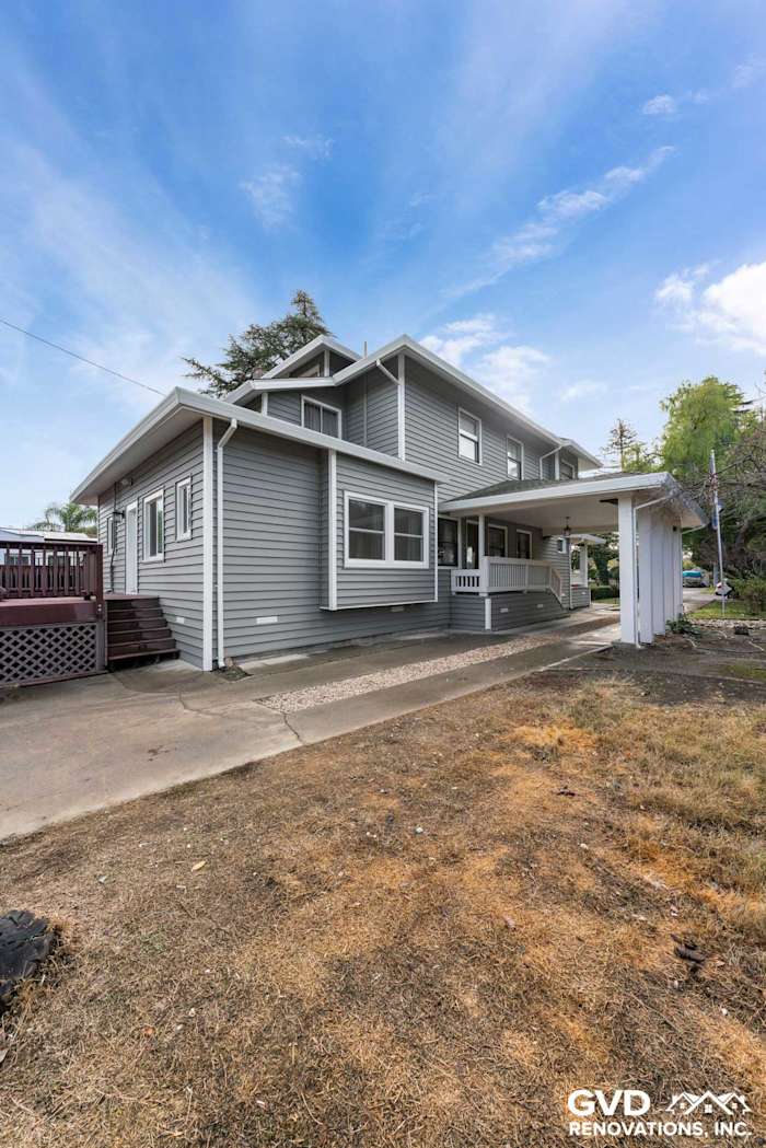 Updated home exterior featuring light gray vinyl siding, new windows, and welcoming porch in Dixon, CA