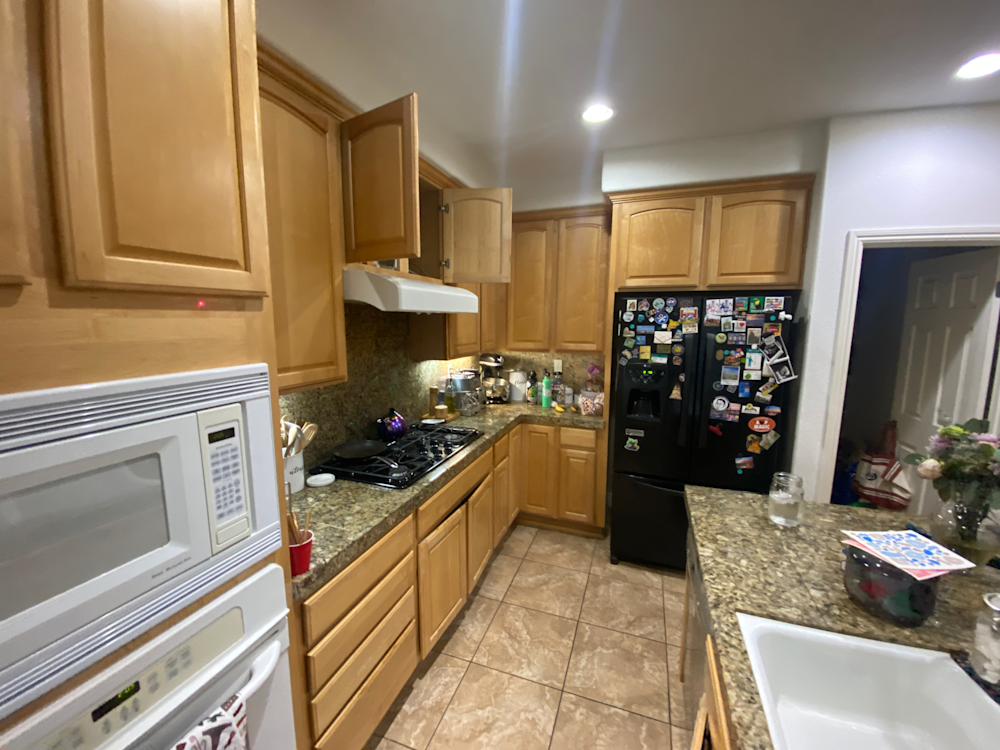 Narrow kitchen with oak cabinets, granite countertops, and black appliances in Sacramento