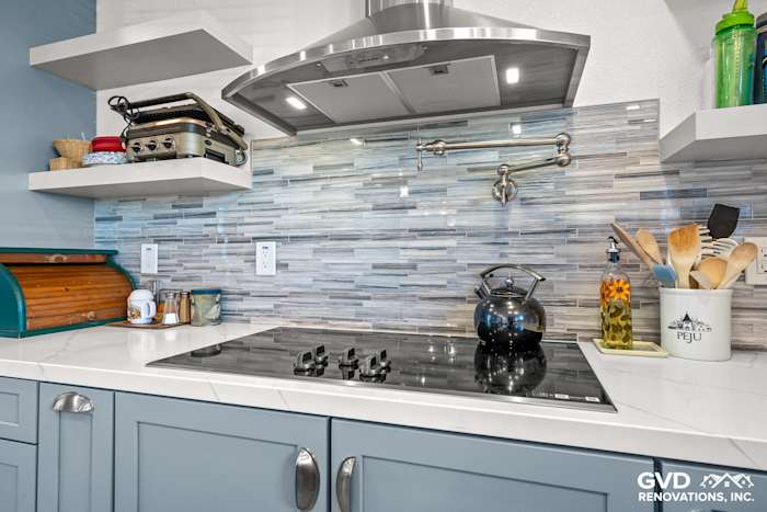 Modern kitchen with MSI Calacatta Ultra countertops, Misty Fjord Linear backsplash, gray cabinets, and stainless steel range