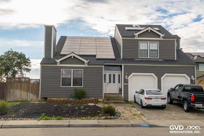 Modern home exterior featuring new Prodigy siding in gray, complemented by solar panels and clean landscaping
