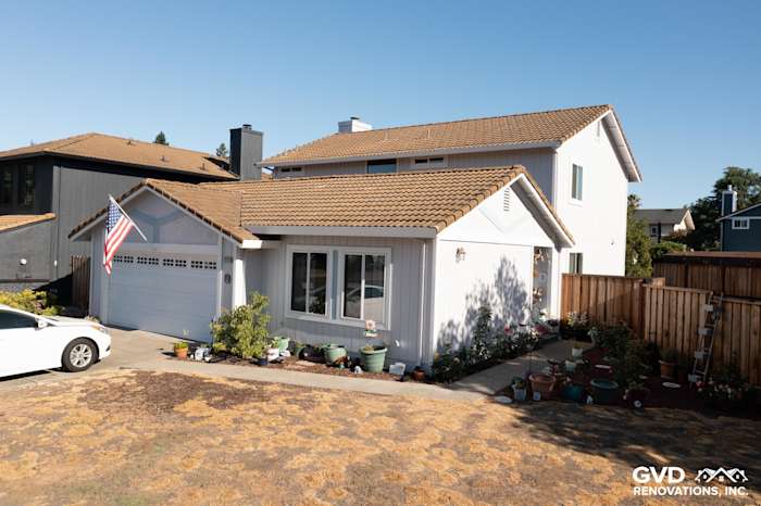 Modern home exterior with new white siding, updated windows, and stone pathway in Petaluma, CA