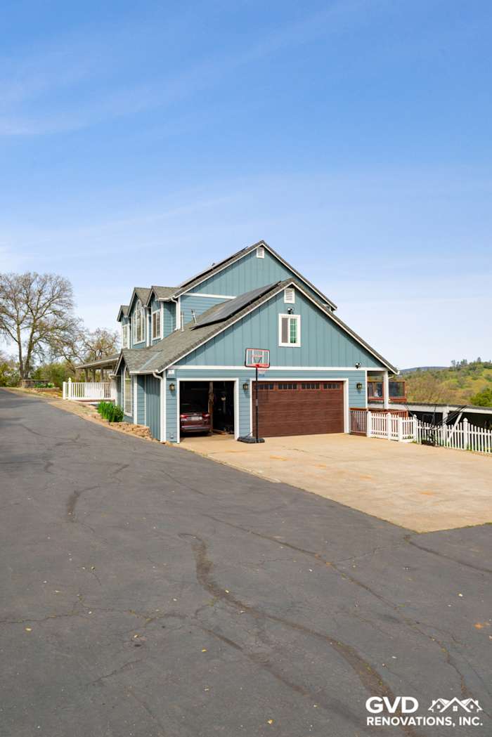 Newly installed James Hardie siding on a blue two-story home in Shingle Springs with a concrete driveway and basketball hoop