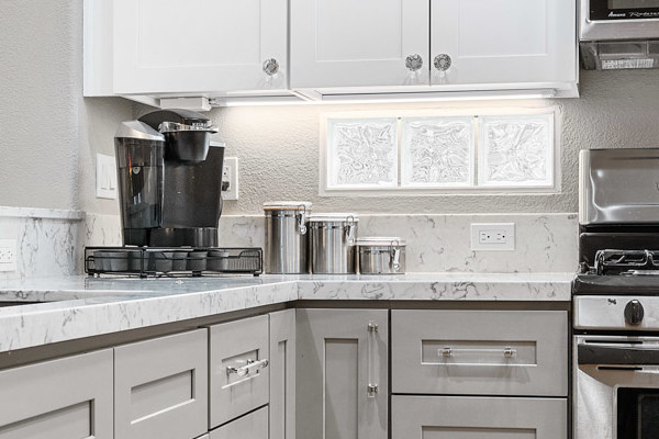 Modern gray and white kitchen with stainless steel appliances, quartz countertops, and bamboo flooring in Roseville