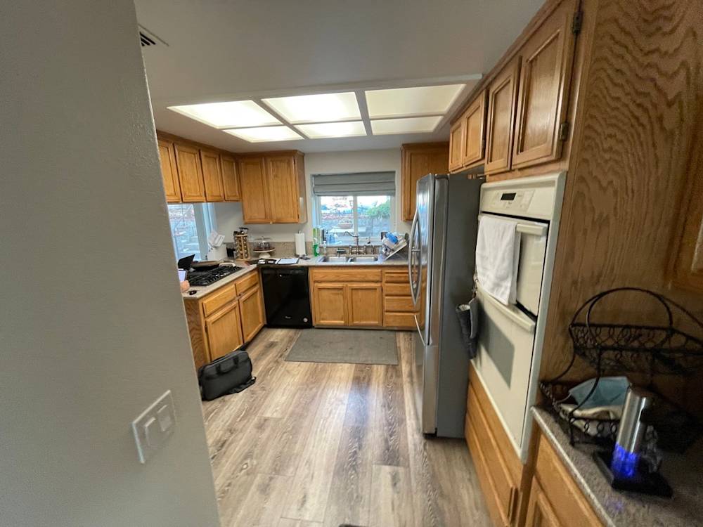 Narrow Rocklin kitchen with oak cabinetry, stainless appliances, and natural light from the window