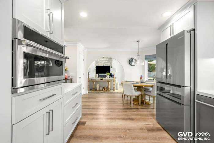 Modern kitchen remodel in Rocklin featuring sleek white cabinets, stainless steel appliances, and stylish wood flooring