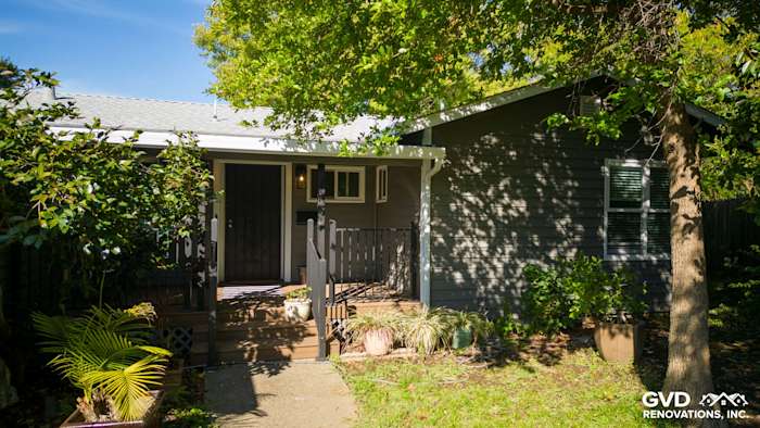 Modern home exterior in Carmichael with new dark gray vinyl siding, Milgard windows, and lush landscaping