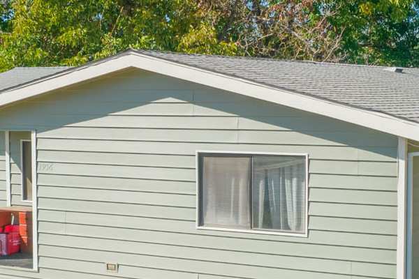 Home exterior featuring newly installed Prodigy siding in light green, surrounded by trees and a yard in Yuba City