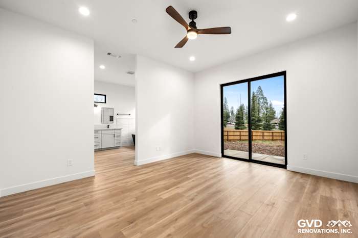 Interior view of a modern living area with a sliding glass door, wood flooring, and high ceilings in a new home