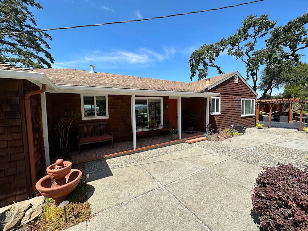 Home exterior featuring brown wood siding, concrete patio, and landscaped garden in Sacramento area