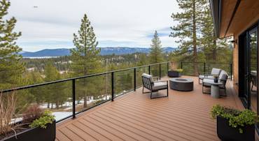 Elegant wooden deck with modern seating and fire pit, surrounded by lush pine trees and mountain views