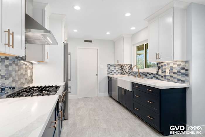 Modern Sacramento kitchen remodel featuring navy blue cabinets, gray quartz countertops, and hexagon tile backsplash