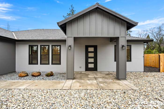 Modern home exterior in Paradise, CA featuring James Hardie Architectural Panels, Milgard windows, and stone pathway