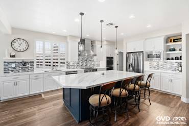 Modern kitchen remodel in El Dorado Hills featuring white cabinetry, gray backsplash, and an island with bar stools