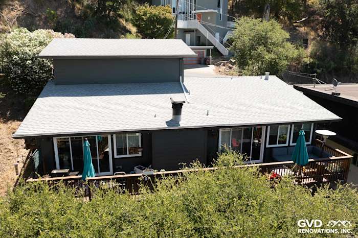 Home exterior featuring James Hardie Lap Siding in Iron Gray with a deck and green umbrellas in Oakland