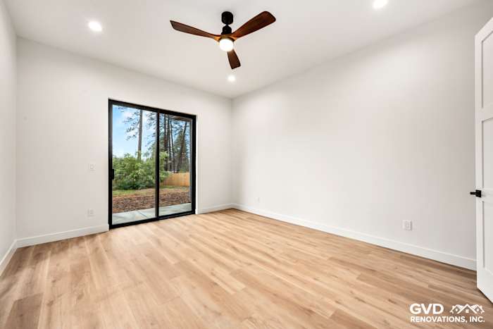 Bright, unfurnished bedroom with wood flooring and sliding glass doors leading to an outdoor patio in Paradise, CA