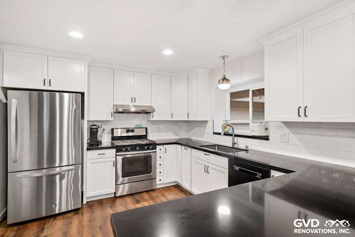 Modern white shaker kitchen with stainless steel appliances, quartz countertops, and dark cabinetry accents in Loomis, CA