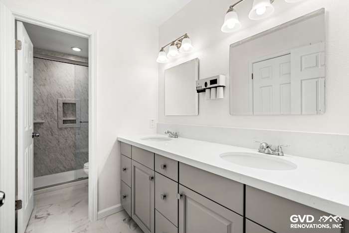 Modern bathroom with double sink vanity, marble countertop, and stylish lighting fixtures in Sacramento remodel