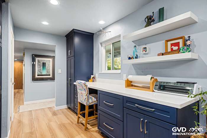 Modern kitchen workspace in Fair Oaks featuring navy cabinets, open shelving, and light wood flooring