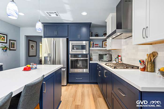 Modern kitchen remodel featuring navy blue cabinets, white countertops, and stainless steel appliances in Fair Oaks, CA