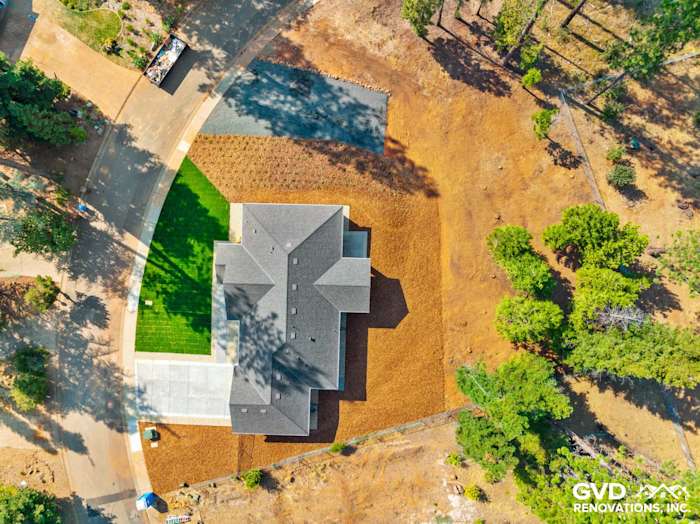 Aerial view of a newly constructed home in Paradise, CA, showcasing landscaping and driveway layout