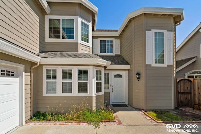 Monterey Taupe James Hardie lap siding with Arctic White trim and Alside Mezzo windows in Foster City home exterior