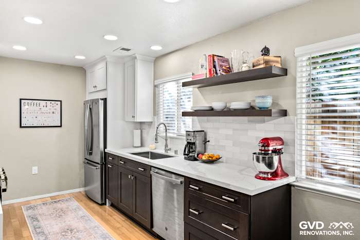 Modern kitchen with stainless steel appliances, quartz countertops, white cabinets, and open shelving in Davis, CA