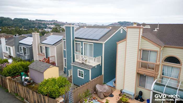 Modern home exterior featuring James Hardie Evening Blue siding, solar panels, and unique architectural design in Daly City